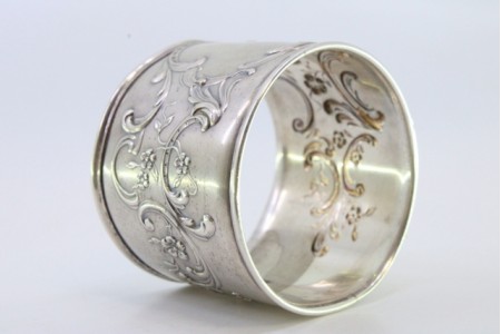 Argola de guardanapo em prata com relevos florais envolvendo cartela para monograma.